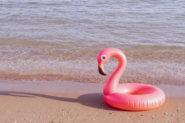 Yaz konsepti geçmişi. Mavi okyanus suyunda pembe şişirilebilir flamingo. Deniz yazı plajı arka planı için. Havuz havuzu partisi