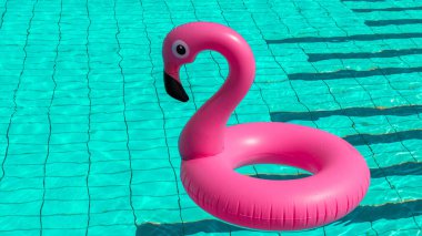 Merhaba yaz. Yaz mevsimi için havuz suyunda şişirilebilir pembe flamingo. Moda yaz konsepti