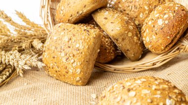 Ev yapımı ekmek. Çavdar ekmeği ve ekmek kırıntılarıyla. Buğday taneli taze köy ekmeği ya da doğal pamuk arka planında dikenli bitki. Fırın ürün etiketi için tasarım ögesi