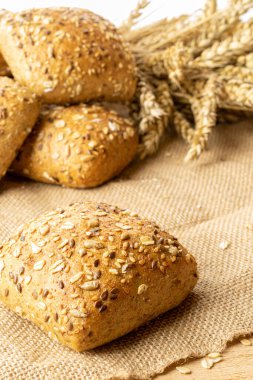 Köy ekmeği. Buğday tohumu kulaklı bir somun taze ekmek ya da keten desenli bir bitki. Çavdar ekmeği ve ekmek kırıntılarıyla. Konsept - Evde Yemek Pişirme