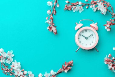 Mayıs çiçekleri. Bahar çiçekleri ve çiçekli Nisan çiçekleri mavi arka planda çalar saat. Çiçek açan ağaçla güzel bir sahne. Paskalya güneşli bir gün. Meyve bahçesi arkaplanı bulanık. İlkbahar