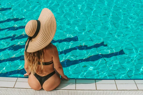 夏の楽しみ 青いプールの水でビキニ水着 サングラス サンハットの幸せな若いセクシーな女の子 楽しい旅行休暇を楽しんでいます スイミングプールの水 — ストック写真