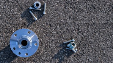 Tamir servisi. Otomobil motoru yedek veya asfalt arka planda otomotiv parçası. Yeni metal araba parçası seti. Siyah bituminimsi desenli su geçirmez.