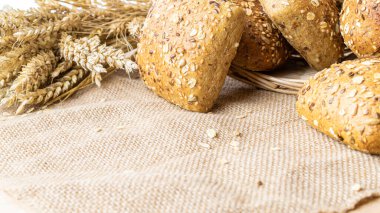 Lezzetli ekmek. Buğday tohumu kulaklı bir somun taze ekmek ya da keten desenli bir bitki. Çavdar ekmeği ve ekmek kırıntılarıyla. Ev yapımı pişirme.