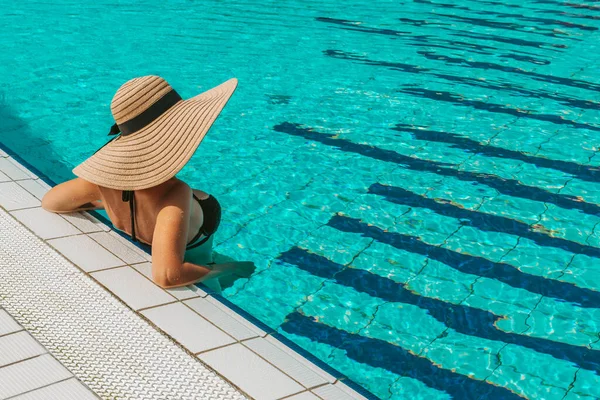 幸せな女の子のプール サンハットの若いセクシーな女性 ビキニ水着 青い水で泳ぐサングラス 喜びの夏のレジャーの自由の概念 — ストック写真