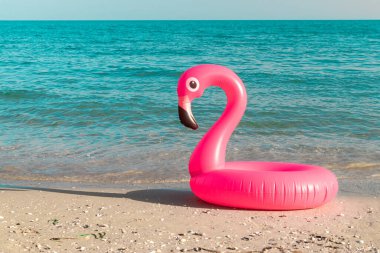 Yaz indirimi. Mavi okyanus suyunda pembe şişirilebilir flamingo. Deniz yazı plajı arka planı için. Asgari yaz konsepti