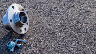 Kısmen izole. Yeni metal araba parçası seti. Otomobil motoru yedek veya otomotiv parçası siyah zemin asfalt dokusunda izole edilmiş. Asfalt koyu gri kumlu yol