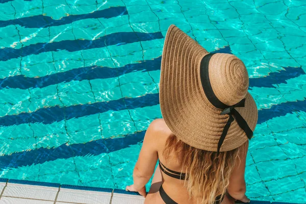 女をプールで 青い水の中でビキニ水着 サングラス 麦藁帽子の幸せな若いセクシーな女の子 ラグジュアリーライフスタイル旅行 — ストック写真