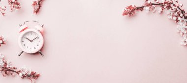 Kiraz ağacı çiçeği. Nisan çiçekleri ve bahar sakura çiçekleri yumuşak pembe arka planda çalar saat ile birlikte. 8 Mart bayrağı, mesaj için yeri olan mutlu Paskalyalar. İlkbahar konsepti