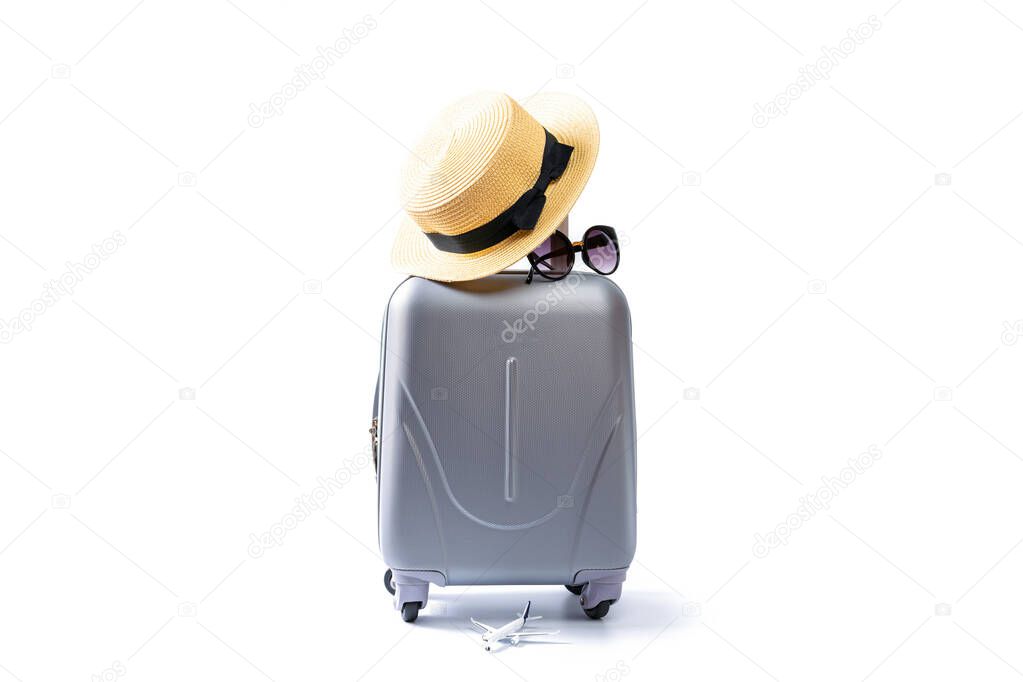 Summer concept background. Travel accessories with suitcase, straw hat, palm leaves in minimal trip vacation concept isolated on white. Copy space, summer vacation and business travel concept