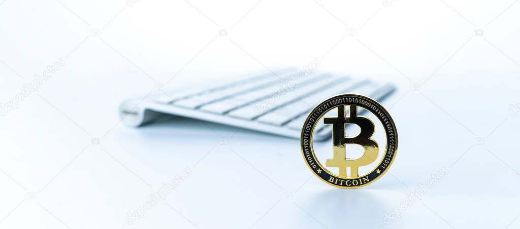 Bitcoin icon. Gold Crypto currency BTC Bitcoin with keyboard on white background. Golden Bit Coin virtual cryptocurrency or blockchain technology. Trading on the cryptocurrency exchange.