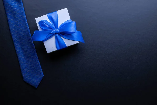 父亲的礼物白色的盒子 有蝴蝶结 蓝色的领带或深色背景的领带 父亲节贺卡的概念 文本复制空间 — 图库照片