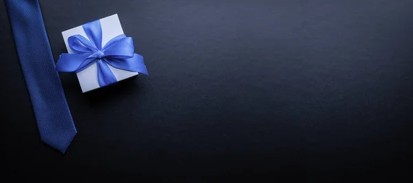 父亲的礼物白色的盒子 有蝴蝶结 蓝色的领带或深色背景的领带 父亲节贺卡的概念 文本复制空间 — 图库照片