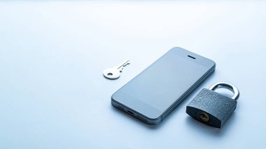 İş güvenliği koruması. Modern uzay gri cep telefonu, asma kilitli, anahtar beyaz arka planda. Akıllı telefon dolandırıcılığı, online dolandırıcılık ve siber güvenlik tehdidi