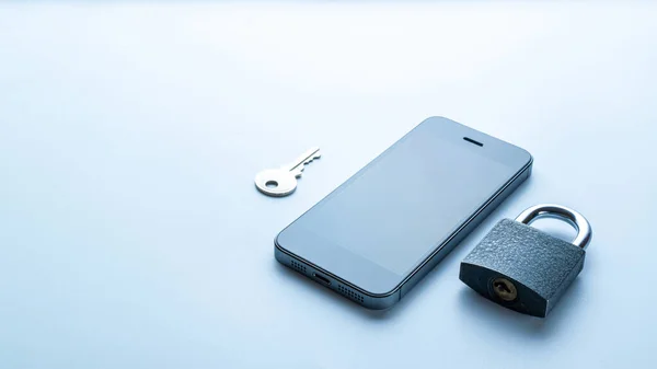 Business security protection. Modern space grey mobile phone with padlock, key on white background. Smartphone fraud, online scam and cyber security threat