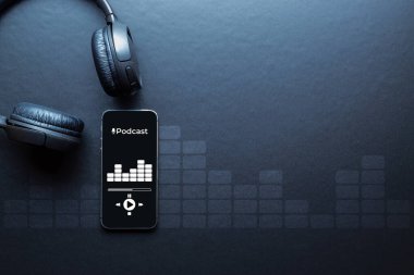 Podcast arka planı. Mobil akıllı telefon ekranı, podcast uygulaması, ses kulaklığı. Telsiz mikrofonlu bir ses. Kayıt stüdyosu veya podcast afişi