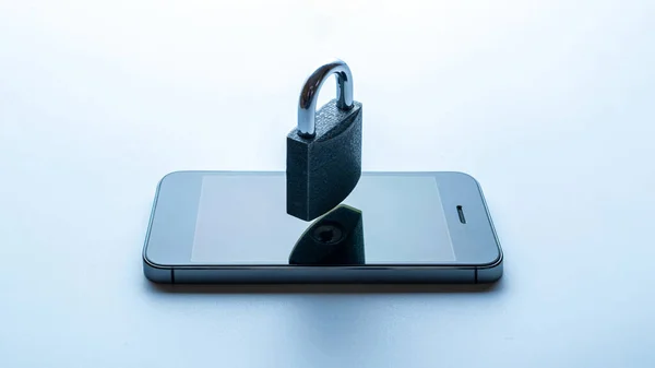 Business security protection. Modern space grey mobile phone with padlock, key on white background. Smartphone fraud, online scam and cyber security threat