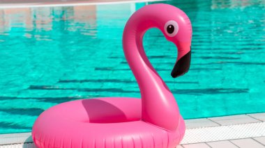 Deniz arka planı. Yaz mevsimi için havuz suyunda şişirilebilir pembe flamingo. Lüks yaşam tarzı seyahati