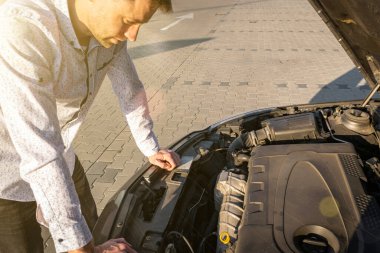 Araba sorunu. Yoldaki kaza üçgeninden sonra sürücü açık kaput otomobili yakınlarında. Araç arızalı veya motor arızası konsepti