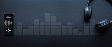 Müzik konsepti. Ses ritimleri, kulaklıklar, cep telefonu ekranında müzik uygulaması. Koyu arkaplanda ses kaydı. Kayıt stüdyosu veya podcast afişi