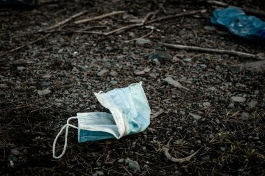 Çevre kirliliği. Ormanda çöp atmak. Ormanda plastik çöp, tıbbi maske. Kullanılan kirli plastik şişelerin ekolojik sorunu