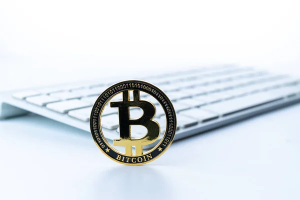 Bitcoin wallet. Golden Bit Coin virtual cryptocurrency or blockchain technology. Gold Crypto currency BTC with keyboard on white background. Investing in virtual assets, Bull market trend concept