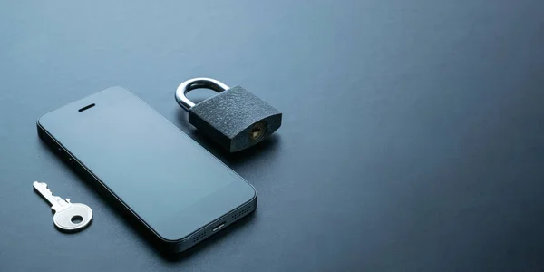 Cyber protection. Modern space grey mobile phone with padlock, key on dark background. Concept of mobile phone security