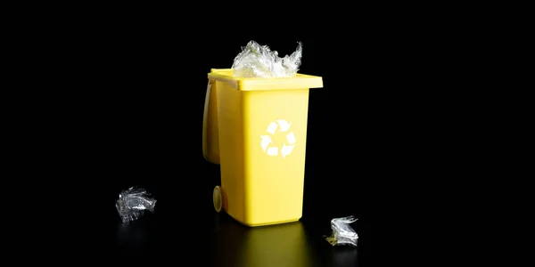 再生プラスチックだ ゴミを処分し 環境を保存するためのビンコンテナ リサイクル紙とガラスのための黄色のゴミ箱は黒の背景に隔離されたゴミができます — ストック写真