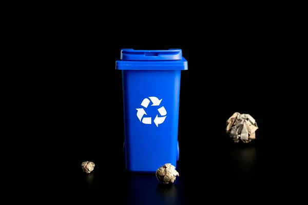 分離紙のリサイクル 黒の背景に隔離された紙のゴミをリサイクルするための青いゴミ箱 ごみの処理と環境の保全のためのビン容器 — ストック写真