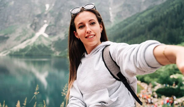 ブロガーの女の子 夏の山の岩の自然を背景にスマートフォンで若い女性旅行写真家 夏の旅行 職業概念 — ストック写真