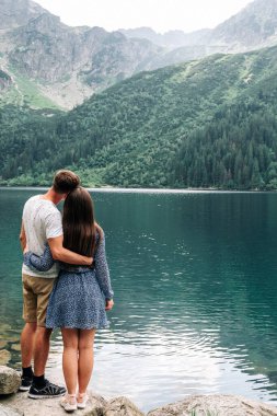 Manzara aşkı. Yaz parkında bir çift kadın ve erkek. Dağ Gölü manzarasında mutlu genç romantik insanlar. Aşk ve Seyahat mutlu duygular Yaşam tarzı konsepti