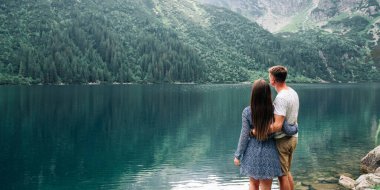 Manzara aşkı. Yaz parkında bir çift kadın ve erkek. Dağ Gölü manzarasında mutlu genç romantik insanlar. Aşk ve Seyahat mutlu duygular Yaşam tarzı konsepti