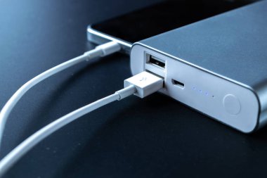 Güç bankasını şarj ediyorum. Şarj cep telefonu ya da akıllı telefon bataryası için beyaz USB kablosu olan taşınabilir güç bankası. Modern teknoloji kavramı