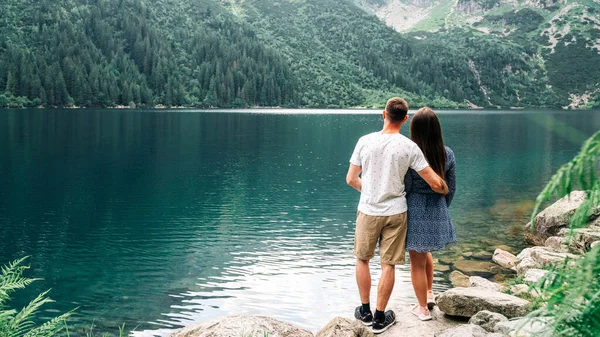 風景の愛。夏の公園で夫婦と女性が一緒に。山の湖の風景で幸せな若いロマンチックな人々。愛と旅行幸せな感情ライフスタイルの概念. — ストック写真