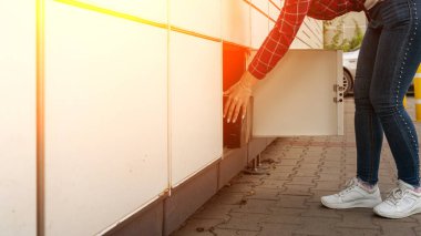 Posta terminali. Otomat terminalinde kadınların elinde bir paket kurye kutusu var. Çevrimiçi satış, e ticaret, paketleme konsepti.