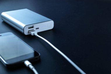 Güç bankasını şarj ediyorum. Şarj cep telefonu ya da akıllı telefon bataryası için beyaz USB kablosu olan taşınabilir güç bankası. Modern teknoloji kavramı