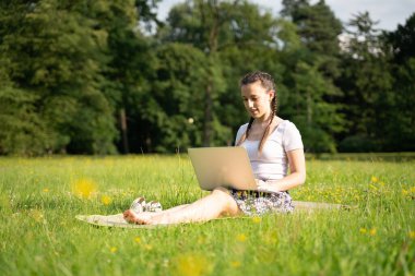 Öğrenci kız arkadaş tablet üzerinde çalışıyor, bilgisayar yaz parkında. Çevrimiçi kadın dışarıda. Laptop açık hava iş teknolojisi. Elektronik aletler uzaklık öğrenme konsepti