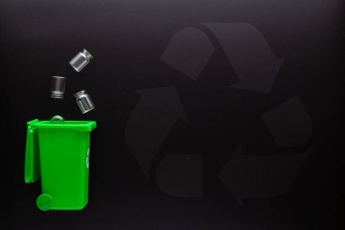Çöp bardağı geri dönüşümü. Çöp konteynırı çöp atmak ve çevreyi korumak için. Siyah arka planda çöp kutuları için yeşil çöp kovası. Üst görünüm