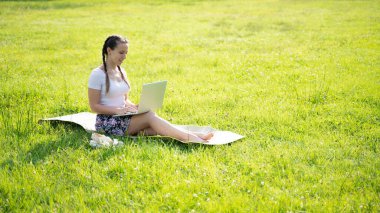 Laptop, bilgisayar işi teknolojisi. Yazlık doğa parkında tablet üzerinde çalışan öğrenci kız. Dışarıdaki insanlar. Kadın internette çalışıyor. Mutlu hipster gençlik öğrenme konsepti.