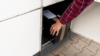 Posta terminali. Otomat terminalinde kadınların elinde bir paket kurye kutusu var. Çevrimiçi satış, e ticaret, paketleme konsepti