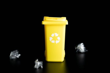 Geri dönüştürülmüş plastik. Çöp konteynırı çöp atmak ve çevreyi korumak için. Geri dönüşüm kağıdı ve çöp kutusu için sarı çöp kutusu siyah arkaplanda izole edildi
