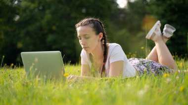Laptop açık hava iş teknolojisi. Öğrenci kız arkadaş tablet üzerinde çalışıyor, bilgisayar yaz parkında. Çevrimiçi kadın dışarıda. Mutlu hipster gençlik öğrenme konsepti