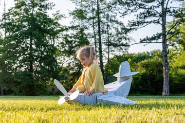 Uçan kız. Sarı karton kostümlü çocuk. Park aktivitesi, gün ışığı çocuğu..