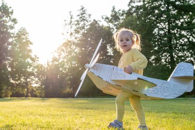 Uçak kostümü. Bebek hayal gücü uçuyor. Açık hava sarı çimen eğlencesi