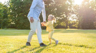 Baba kızı. Baba gün batımında küçük kızıyla koşuyor.
