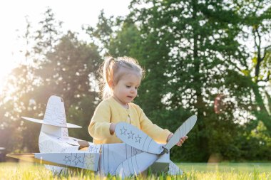 Küçük pilot. Uçak karton çocuk kostümü. Fantezi oyunu sarı çimen
