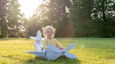 Uçak kostümü. Bebek hayal gücü uçuyor. Açık hava sarı çimen eğlencesi