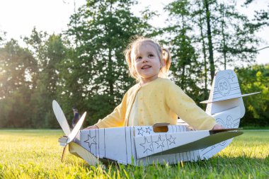 Uçağı olan çocuk. Kız karton pilot oyuncağı. Hayal gücü açık hava kostüm yazı