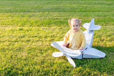 Uçak çocuğu. Uçan karton pilot kız. Açık hava sarı kostüm parkı