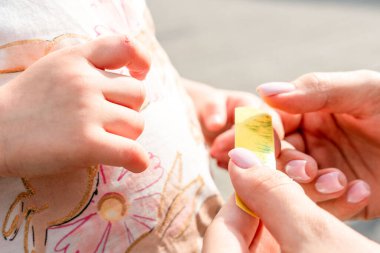 Çocuk parmağı yaralanması. Yeni yürümeye başlayan çocuk dışarıda yapışkan destek alıyor. Aile refahı kavramı